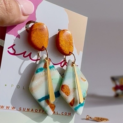 Brincos laranja com pendente pedra branca com manchas e barra dourada