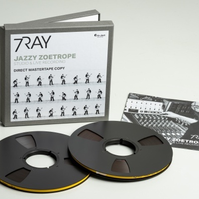 Conjunto de fita magnética e caixa cinzenta com etiqueta branca com texto e cartão preto e branco ao lado