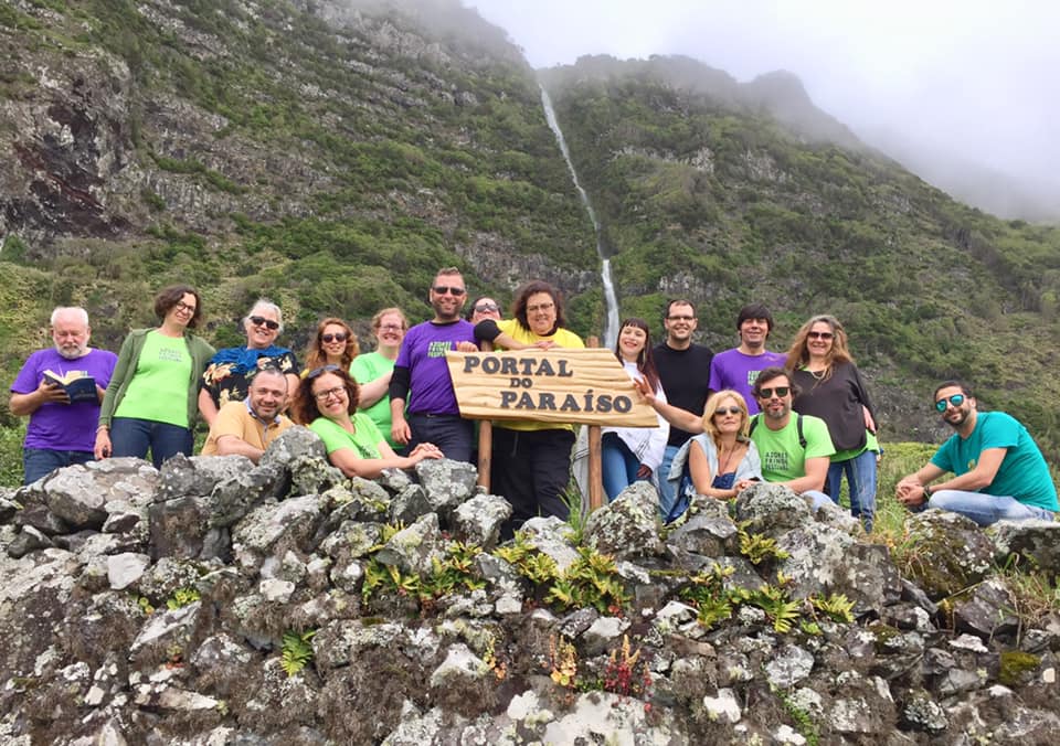Grupo em área montanhosa com placa 'PORTAL DO PARAÍSO'