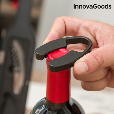 Pessoa a usar saca-rolhas preto para abrir garrafa de vinho com cápsula vermelha e marca InnovaGoods