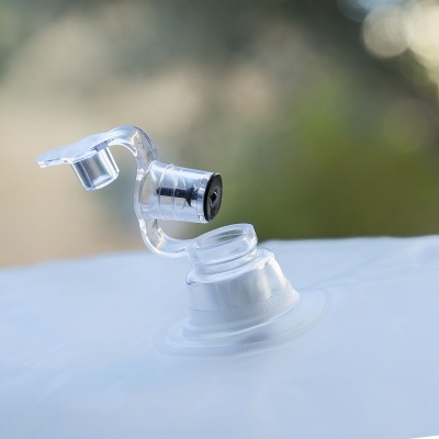 Válvula de plástico transparente com tampa aberta sobre superfície branca