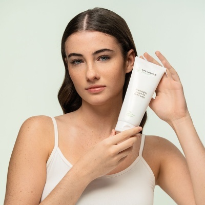 Mulher segurando tubo branco de loção Calmante da marca INNOCOSO