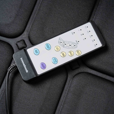 Comando retangular preto com botões coloridos sobre tecido preto acolchoado