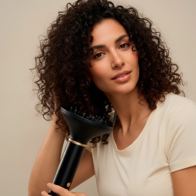 Mulher com cabelo encaracolado a usar difusor preto para secador.