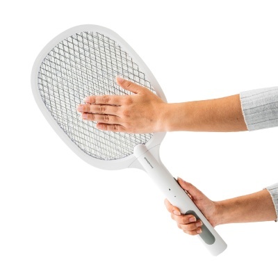 Raquete elétrica branca para insetos com rede metálica sendo segurada por duas mãos