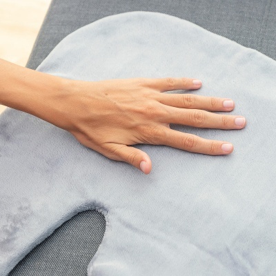 Almofada cinza macia com mão pousada em cima