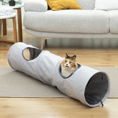 Túnel para gatos cinzento com gato dentro, sofá e mesa ao fundo