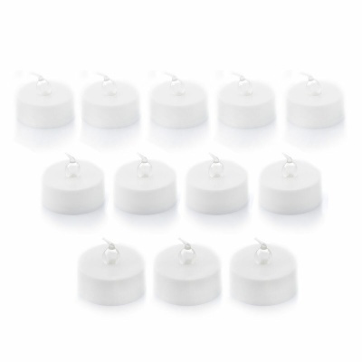 Velas tealight brancas pequenas dispostas em chão branco