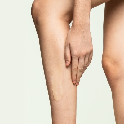 Pernas nuas com líquido transparente aplicado na pele