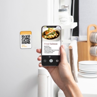 Smartphone a mostrar receita de Fried Salmon junto a frigorífico com código QR colado.