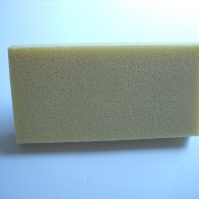 Esponja retangular bege claro com textura porosa