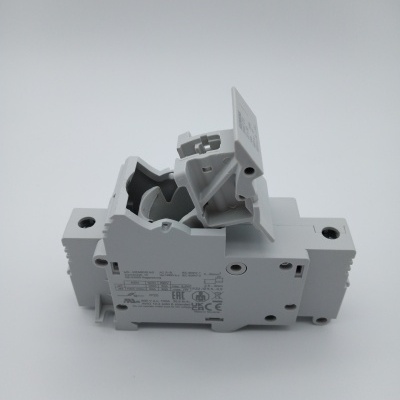 Disjuntor elétrico branco com tampa amovível e texto técnico