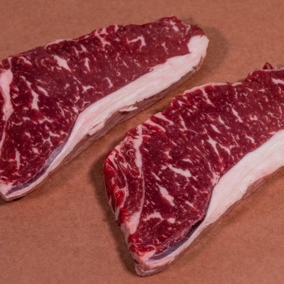 Dois bifes crus com marmoreio e gordura na borda