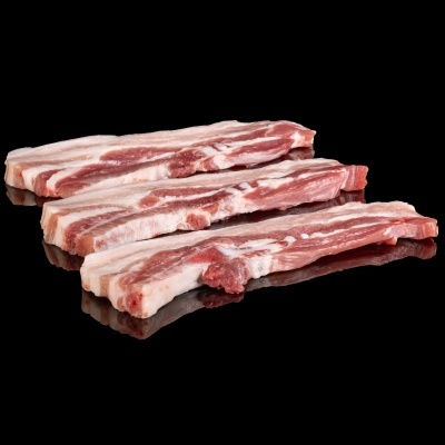 Três tiras de carne crua branca e vermelha num fundo preto