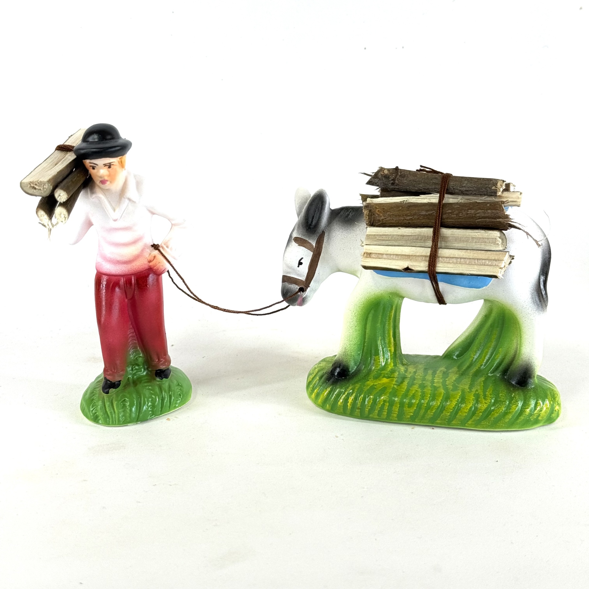 Homem a puxar burro com lenha