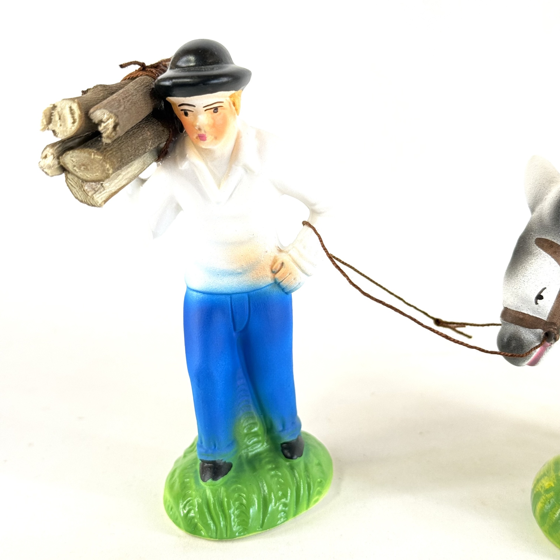 Homem a puxar burro com lenha