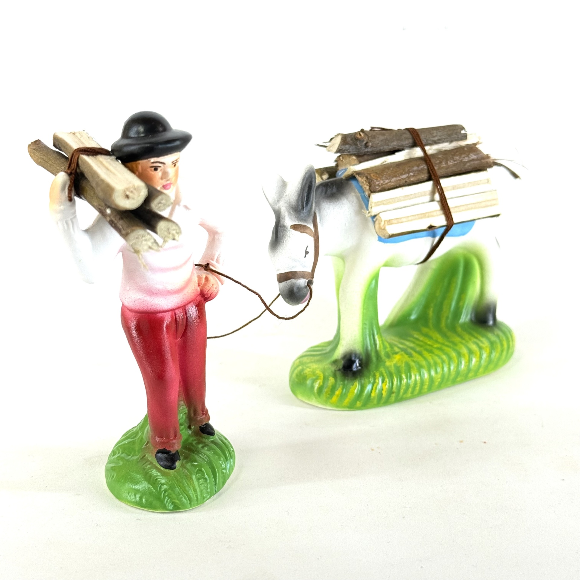 Homem a puxar burro com lenha