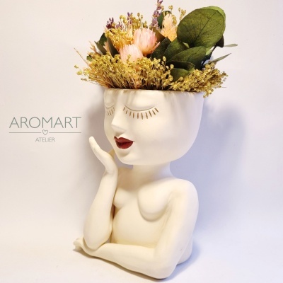 Jarra com rosto e flores preservadas