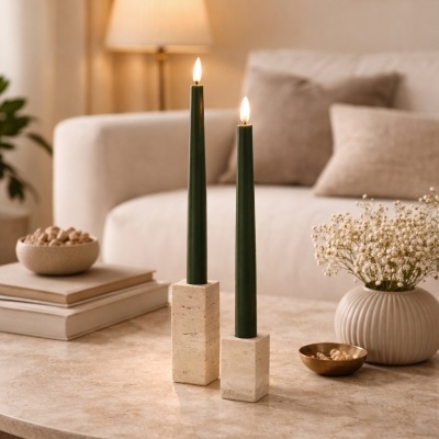 Castiçais em pedra com velas verdes acesas numa mesa de mármore numa sala de estar