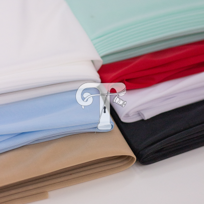 Tecidos dobrados em várias cores lisas sobre uma superfície branca