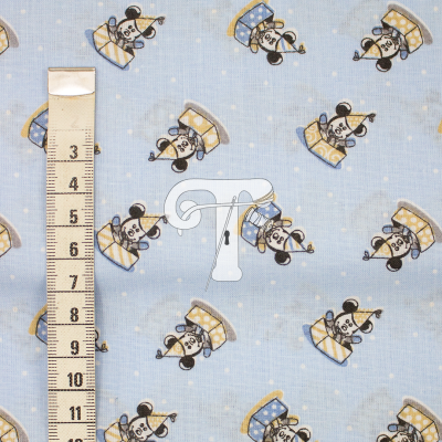 tecido azul claro com padrão de cães e fita métrica ao lado