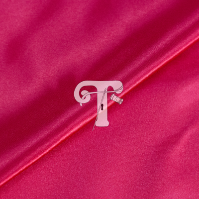 Tecido rosa cetim com letra T decorativa, alfinete e linha enrolada