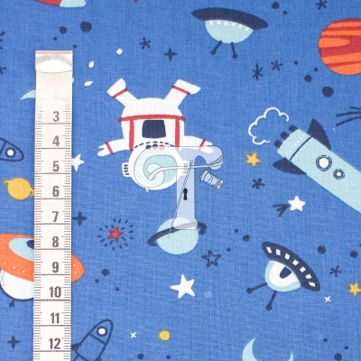 Tecido azul com padrão espacial e fita métrica até 12 cm