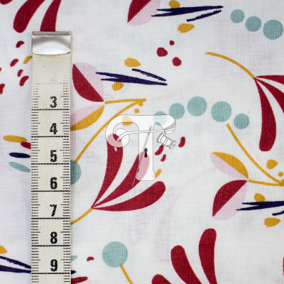Tecido branco com padrão floral colorido e fita métrica ao lado