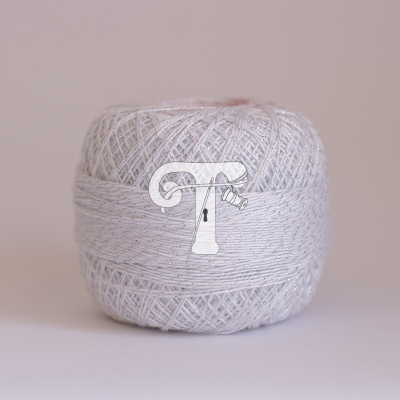 Rolo de linha branca com brilho prateado sobre superfície branca