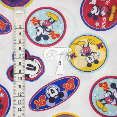 Tecido branco estampado com personagens do Mickey Mouse coloridos e régua de medição ao lado.