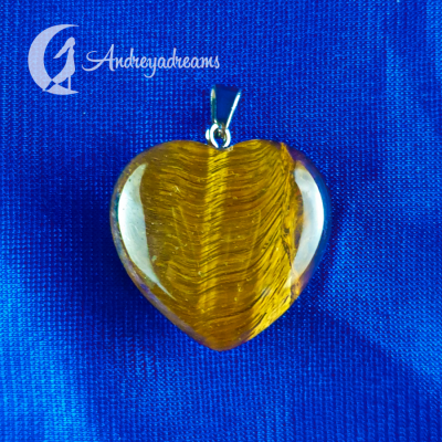 Pingente coração âmbar com base prata sobre tecido azul com texto Andreyadreams