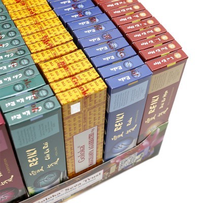 Caixa com pacotes de incenso coloridos de marcas variadas em suporte