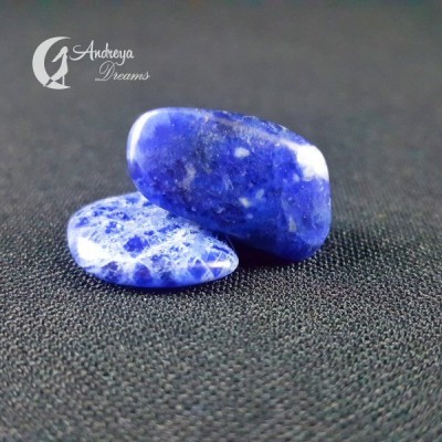 Dois cristais azuis polidos sobre tecido preto com texto Andreya Dreams