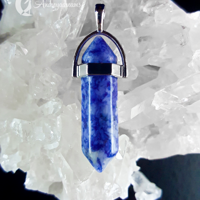 Colar com pendente de cristal azul e suporte metálico prateado sobre cristais brancos