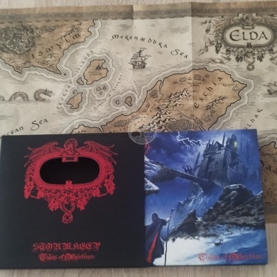 Mapa vintage com texto ELDA e dois livros álbuns, um preto com dragão vermelho e outro azul com castelo e relâmpagos