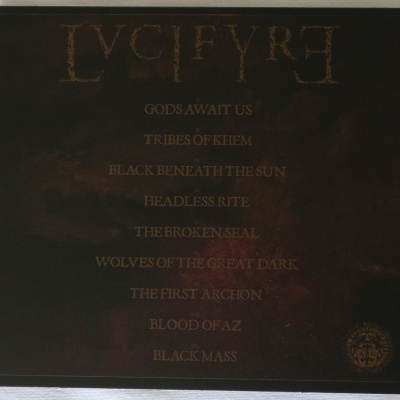 Capa de álbum preto com texto dourado e lista de músicas