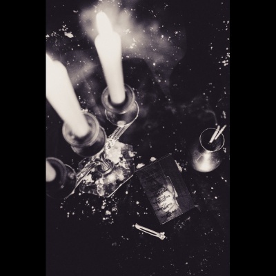 Castiçais de vidro com velas e maço de cigarro Viceroy Filter num fundo escuro.