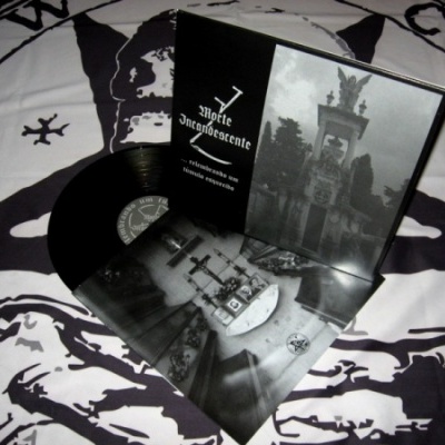 Disco de vinil preto com capa e folheto a preto e branco sobre tecido estampado preto e branco.