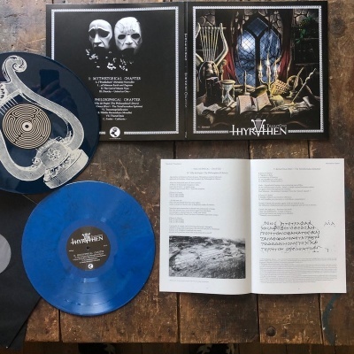 Conjunto de vinis, capas e livreto aberto sobre mesa de madeira