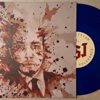 Disco vinil azul translúcido com capa ilustrada em tons castanhos de rosto fragmentado por manchas