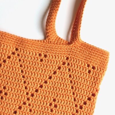 Sacola de crochet laranja com padrão geométrico