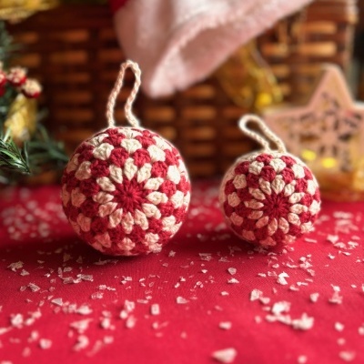 Ornamentos de Natal de croché em vermelho e creme com decoração de Natal em fundo vermelho
