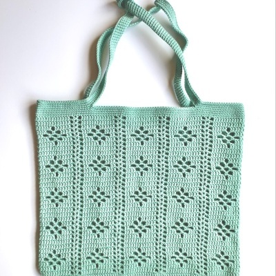 Saco de crochet verde água com padrão de flores recortadas e alças longas