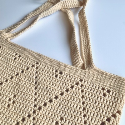 Saco de crochet bege com padrão geométrico e alças trançadas