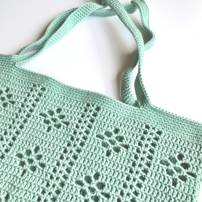 Bolsa verde pastel de crochê com padrão floral e alças finas