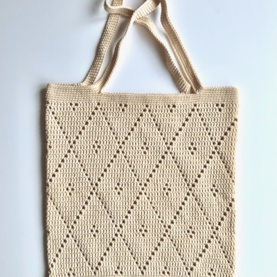 Sacola de crochê bege com alças longas e padrão de losangos