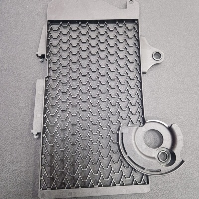 Peça preta de plástico com padrão em zig-zag e peça circular anexada