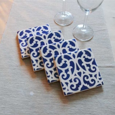 Jogos americanos azuis e brancos sobre mesa de madeira clara com copos de vinho