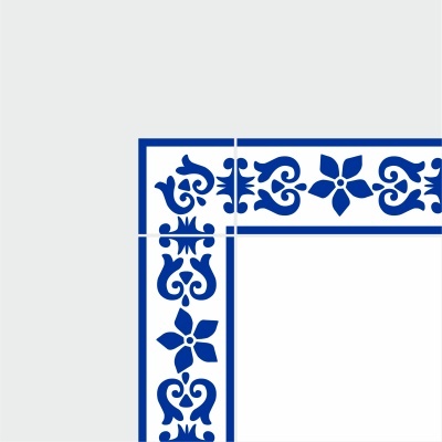 Corner formed by four white ceramic tiles with blue floral and scroll border pattern