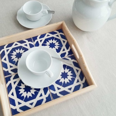 Bandeja de madeira com azulejos azuis e brancos e chávena de café branca